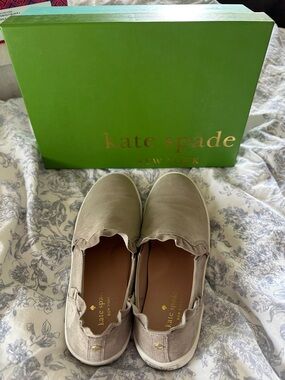 kate spade slip-on sneakers in taupe with gold logo